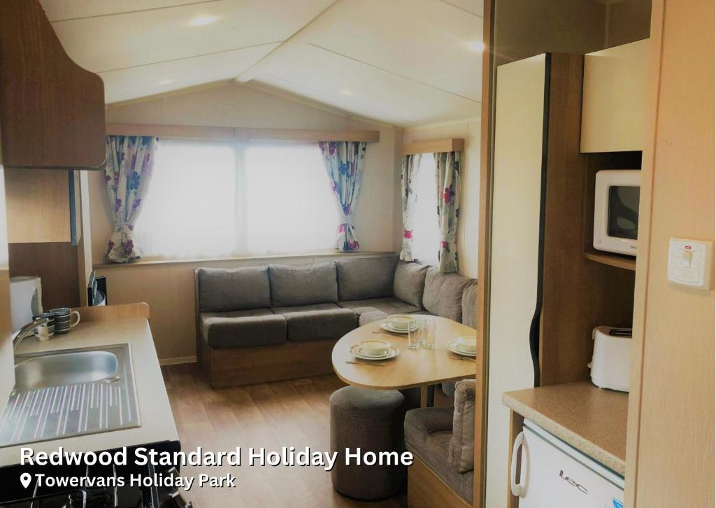 a small living room with a couch and a table at Redwood Standard Holiday Home in Mablethorpe
