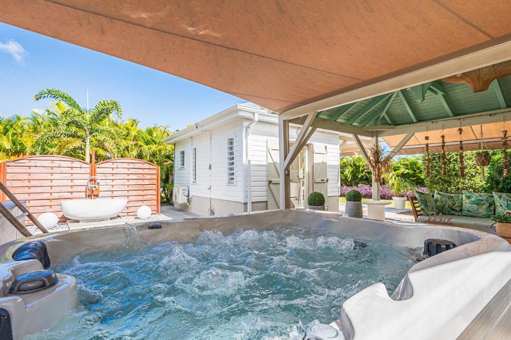 a large jacuzzi tub on a patio at Magnifique Bungalow et Jacuzzi au cœur des plages in Le Moule