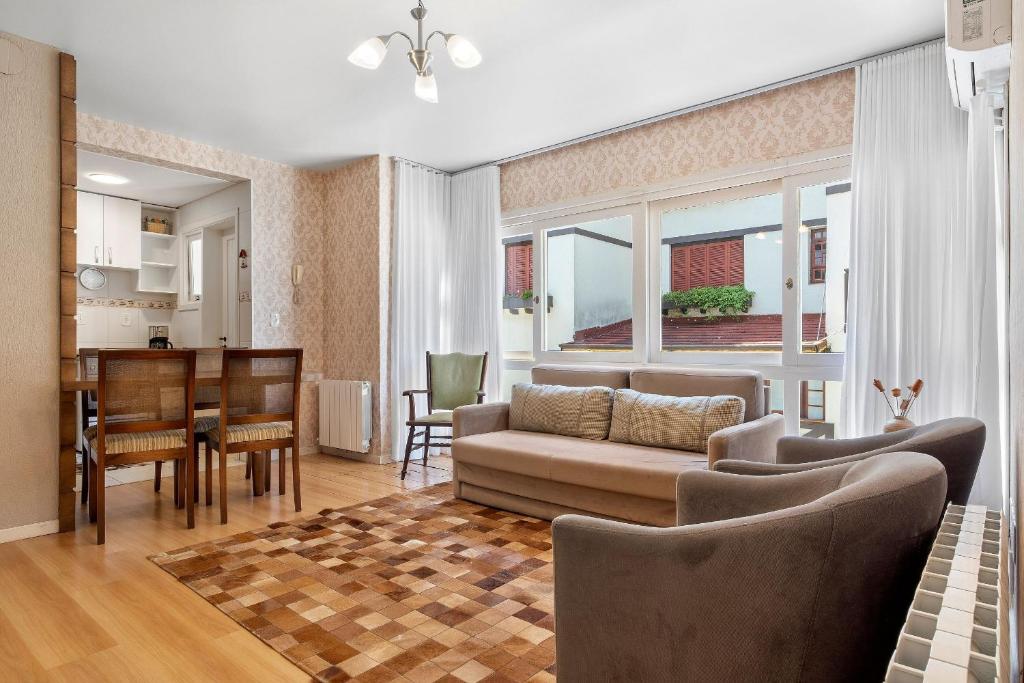a living room with a couch and a table at Morada da Montanha 2 dorm by Achei Gramado in Gramado
