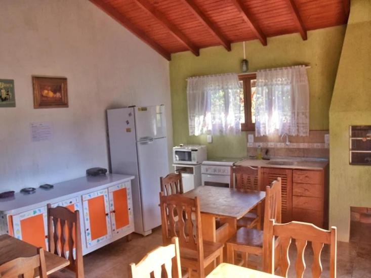 uma cozinha com uma mesa e cadeiras e um frigorífico em Green house na Praia do Rosa