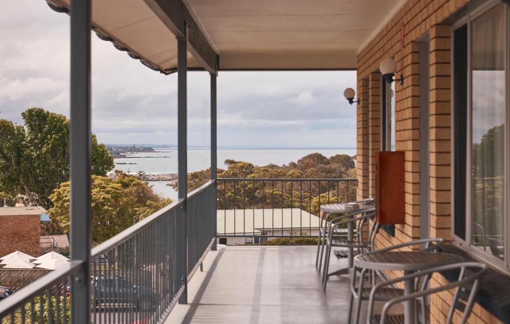 a balcony with chairs and a view of the water at Coastal Comfort Motel in Narooma