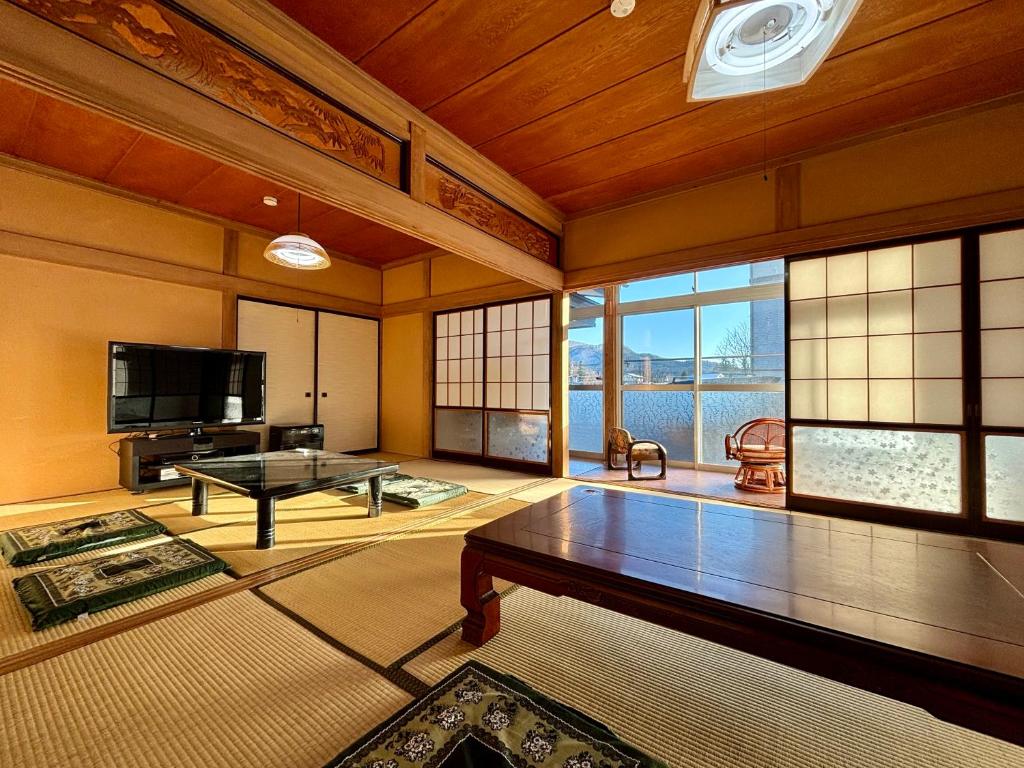 a living room with a table and a tv at Snow Fever - Clan in Hakuba