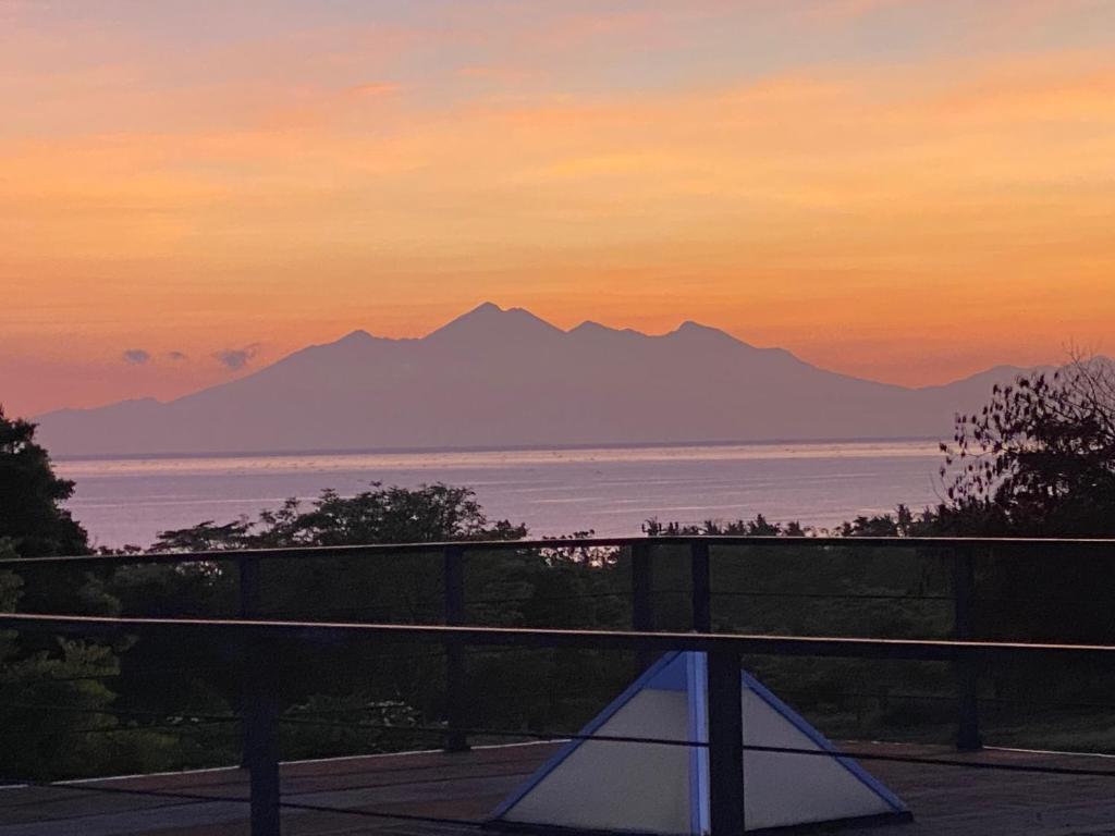 uitzicht op de oceaan en de bergen bij zonsondergang bij Makati Walassey Villa in Karangasem