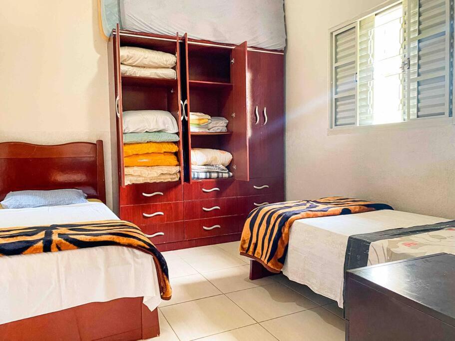 a room with two beds and a shelf with towels at Casa entre Cabo Frio e Arraial do Cabo in Cabo Frio