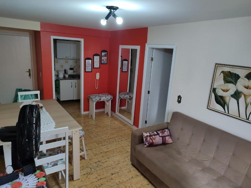 馬蒂尼奧斯的住宿－Apartamento Caiobá Pé na areia. Quadra do Mar.，客厅配有沙发和桌子
