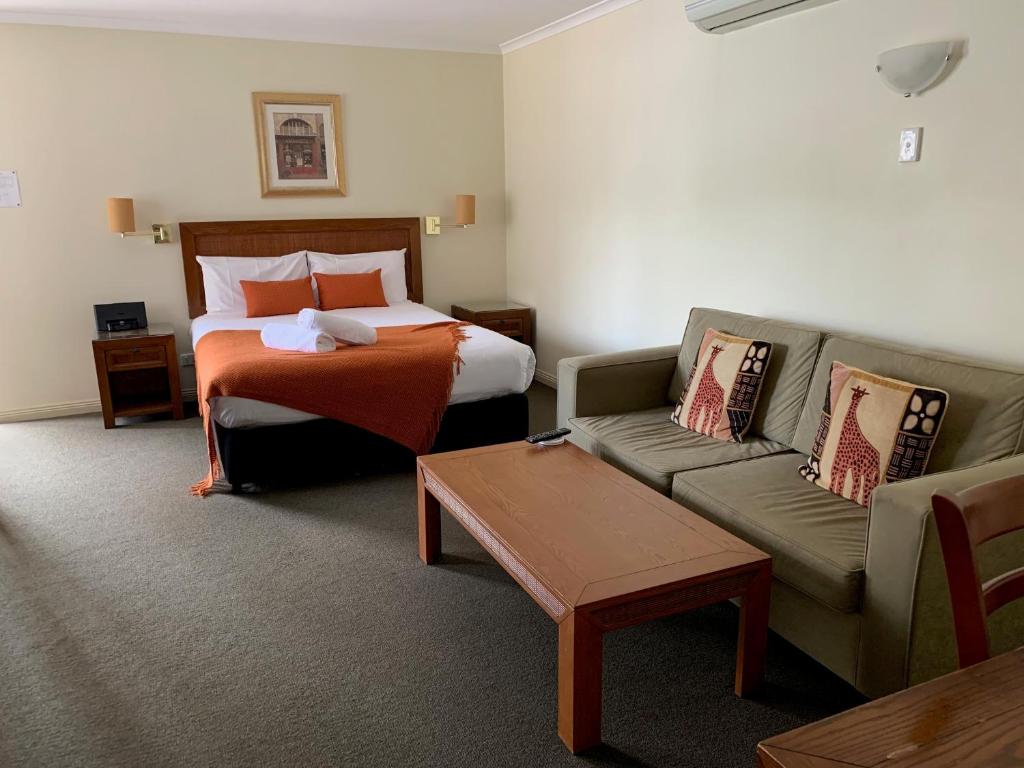 a hotel room with a bed and a couch at Armidale Pines Motel in Armidale