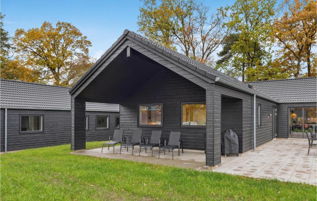 una casa negra con techo inclinado y sillas en Aqua 298, en Charlottenthal