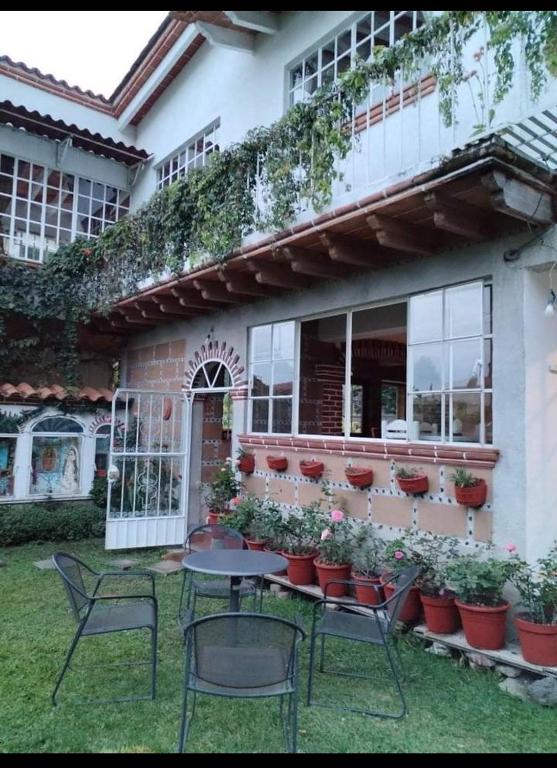 un tavolo e sedie di fronte a una casa di Casa Sauces a Tepoztlán