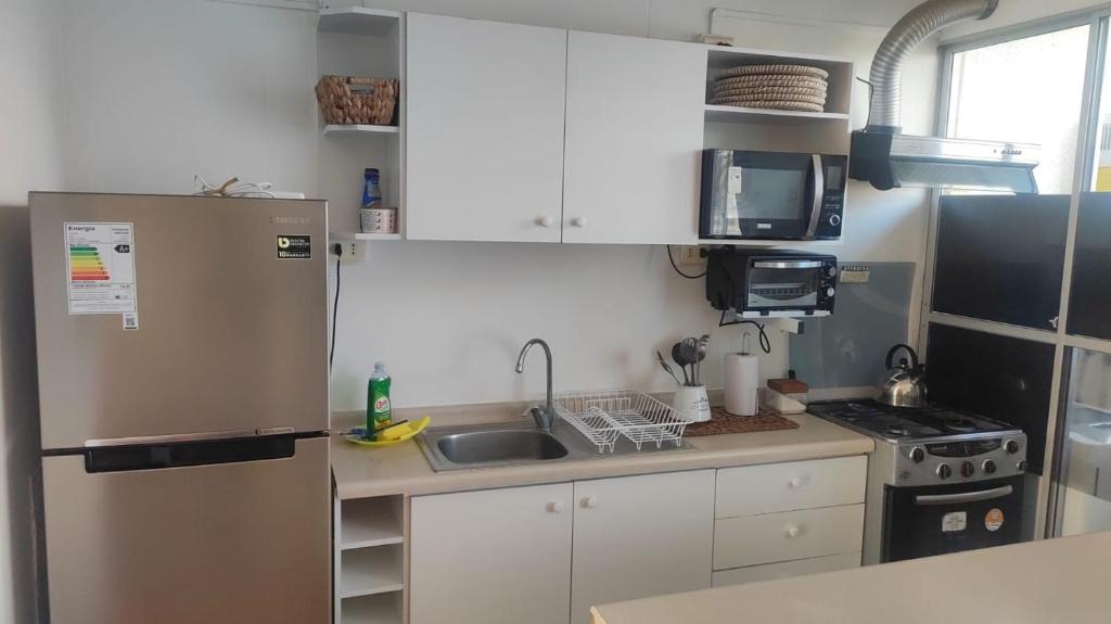 una piccola cucina con frigorifero e lavandino di Departamento La Serena, amoblado, 2 habitaciones, a una cuadra de la playa a La Serena