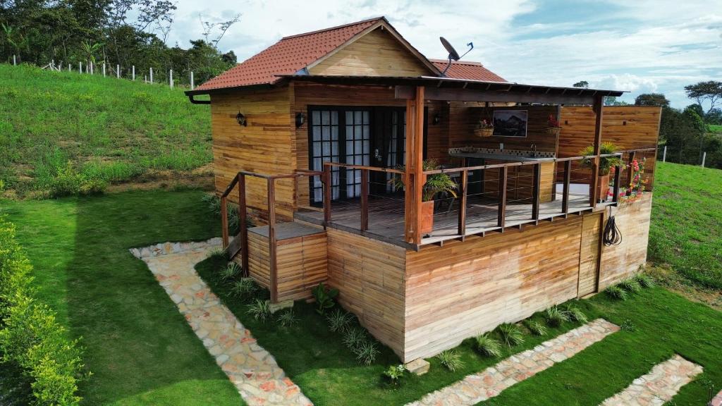 a wooden house with a deck on a field at Chalets La Zima - Jaya in Curití