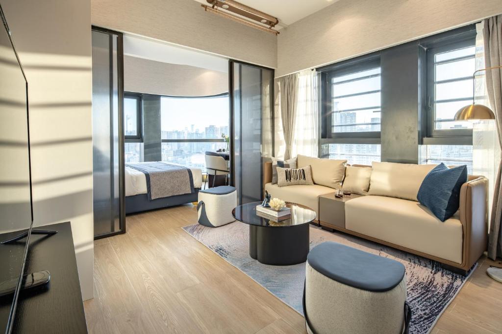 een woonkamer met een bank en een bed bij BORUISI Executive Apartment in Shenzhen