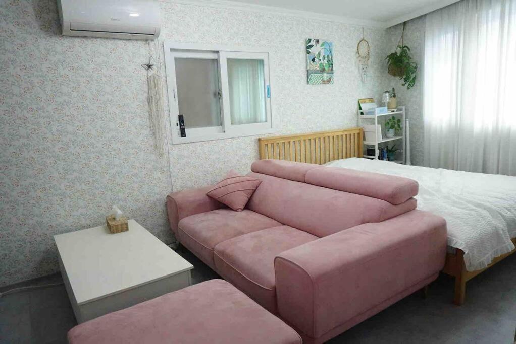 a living room with a pink couch and a bed at Gurosien 3 bedroom house in Seoul