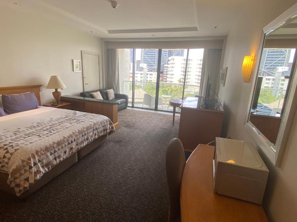 a hotel room with a bed and a living room at Oaks resort in Gold Coast