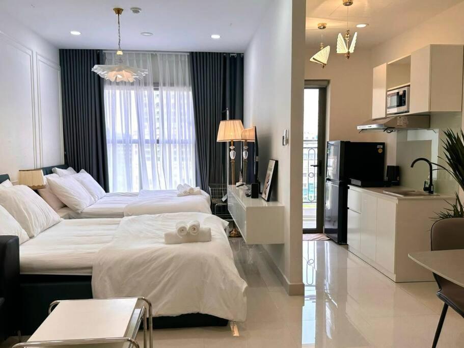 a large bedroom with two beds and a kitchen at New Saigon Royal Luxury Condo 4pax Best City View in Ho Chi Minh City