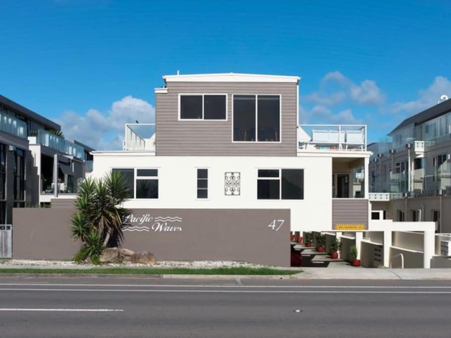 una casa blanca y gris al costado de una calle en Marine Magic, en Mount Maunganui