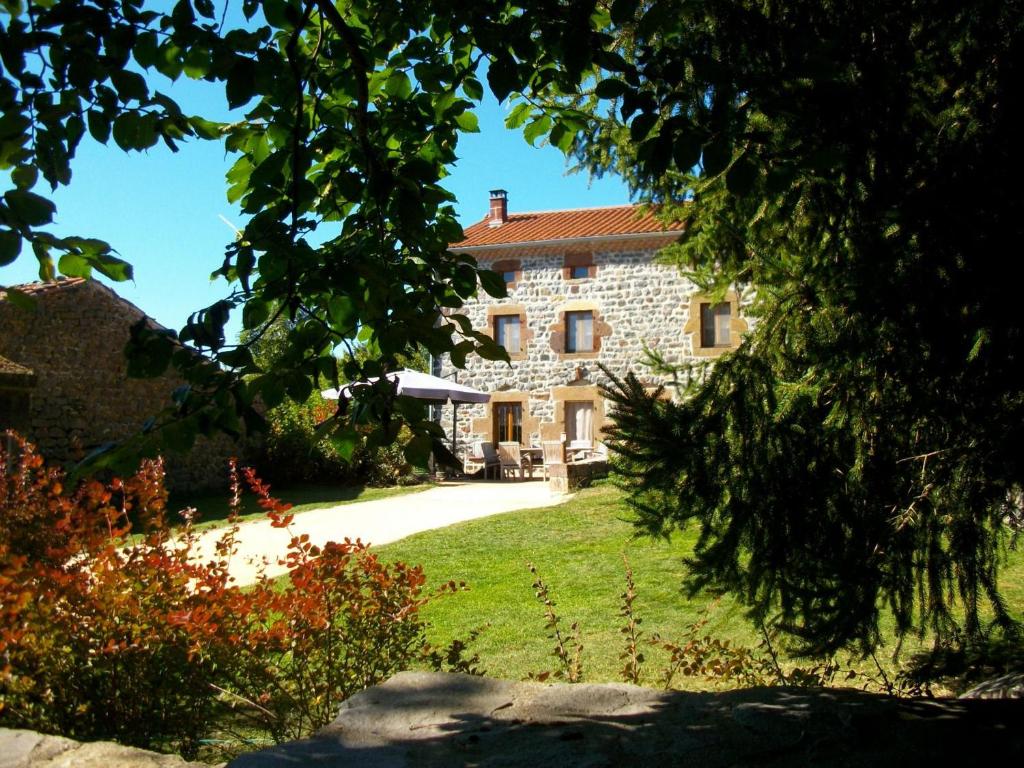 une grande maison en pierre avec une cour herbeuse dans l'établissement Guestroom Saint-Privat-d'Allier, 1 pièce, 2 personnes - FR-1-582-409, à Saint-Privat-dʼAllier