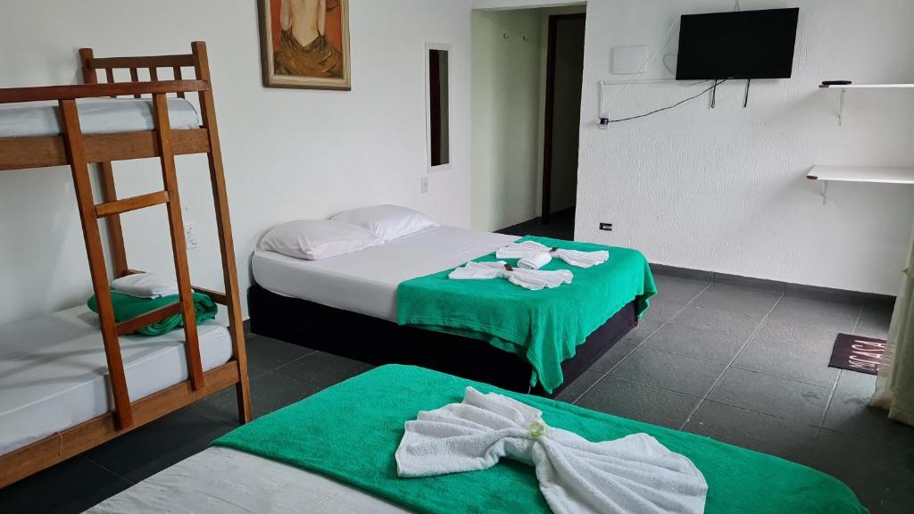 A bed or beds in a room at Porto Suítes Peruíbe