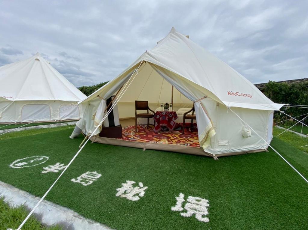 a tent with a table and chairs in it at Baishawan Marina B&B in Shimen