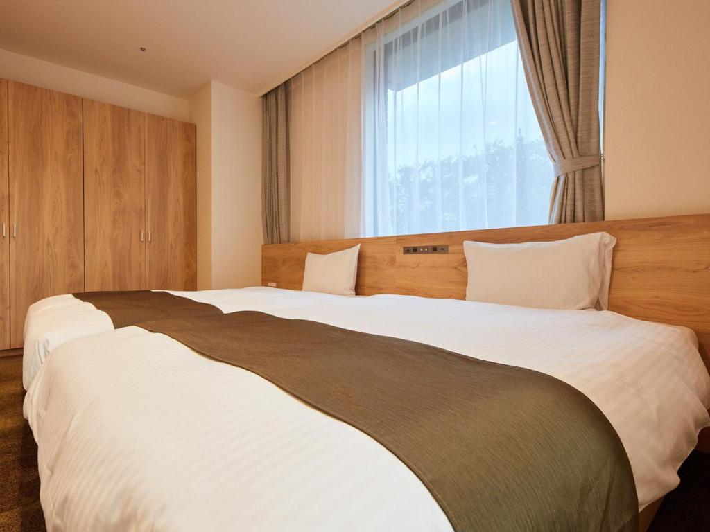 Postel nebo postele na pokoji v ubytování Rembrandt Hotel Atsugi