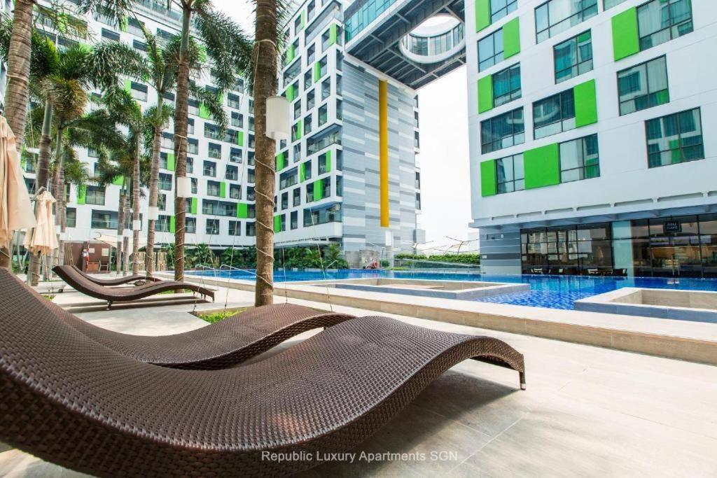a brown chair sitting next to a pool in a building at Republic Apartment Nearby Airport Free Pool Gym in Ho Chi Minh City