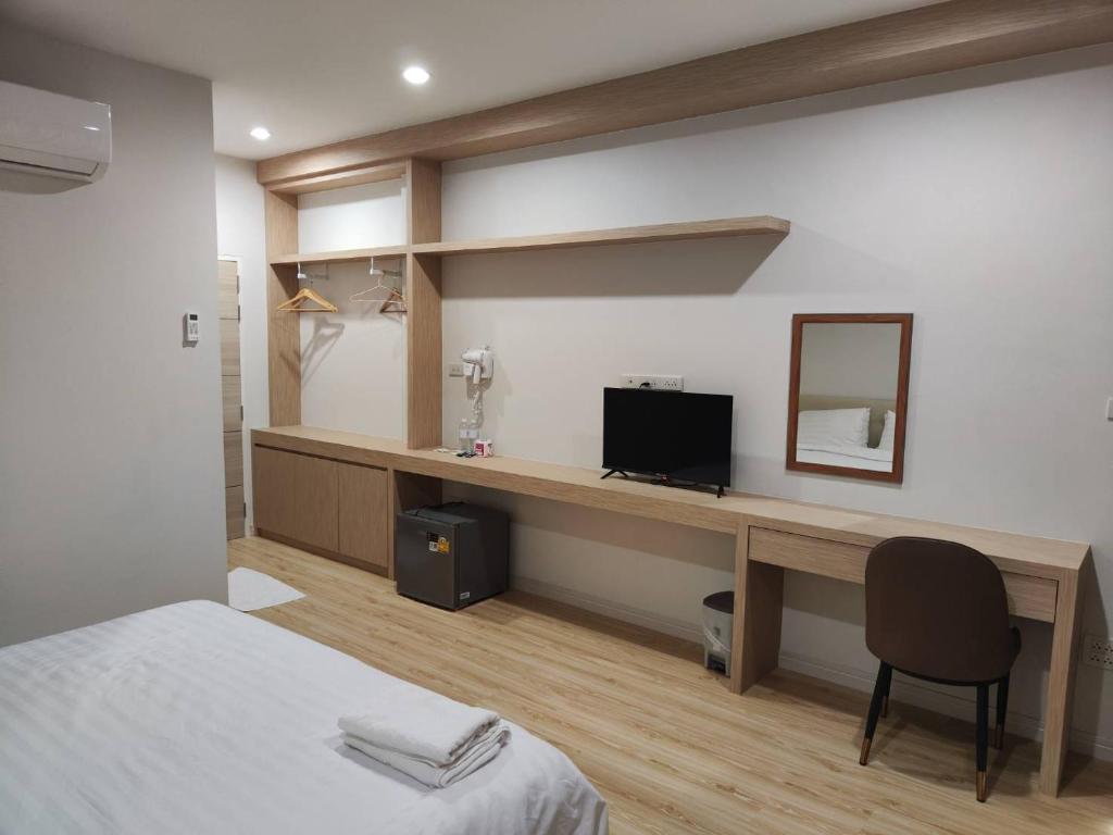 Ban Wang Khanaiにあるโฮมเทลのベッドルーム1室(ベッド1台、デスク、テレビ付)