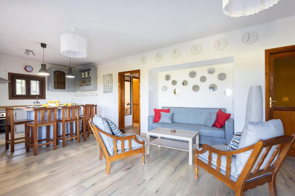 un soggiorno con divano blu e una cucina di Lightbooking Casa de campo Ortigal Tenerife a La Caridad