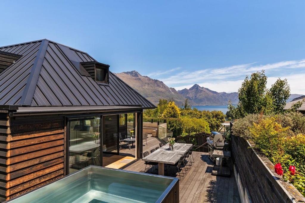 a house with a hot tub on a deck at Mountain Utopia in Queenstown