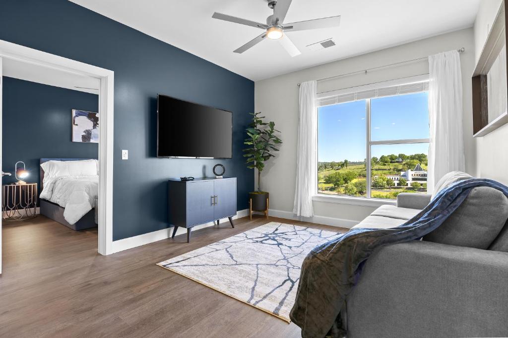 een woonkamer met een bank en een tv bij Beverly Hills Suite Penthouse The Gulch in Nashville