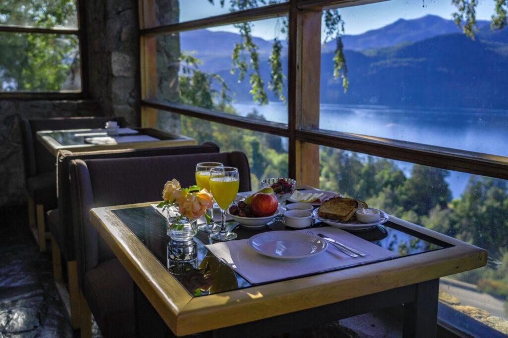 - une table avec un plateau de nourriture et de boissons ainsi qu'une fenêtre dans l'établissement CABAÑA EN SAN MARTIN DE LOS ANDES- paihuen, à San Martín de los Andes