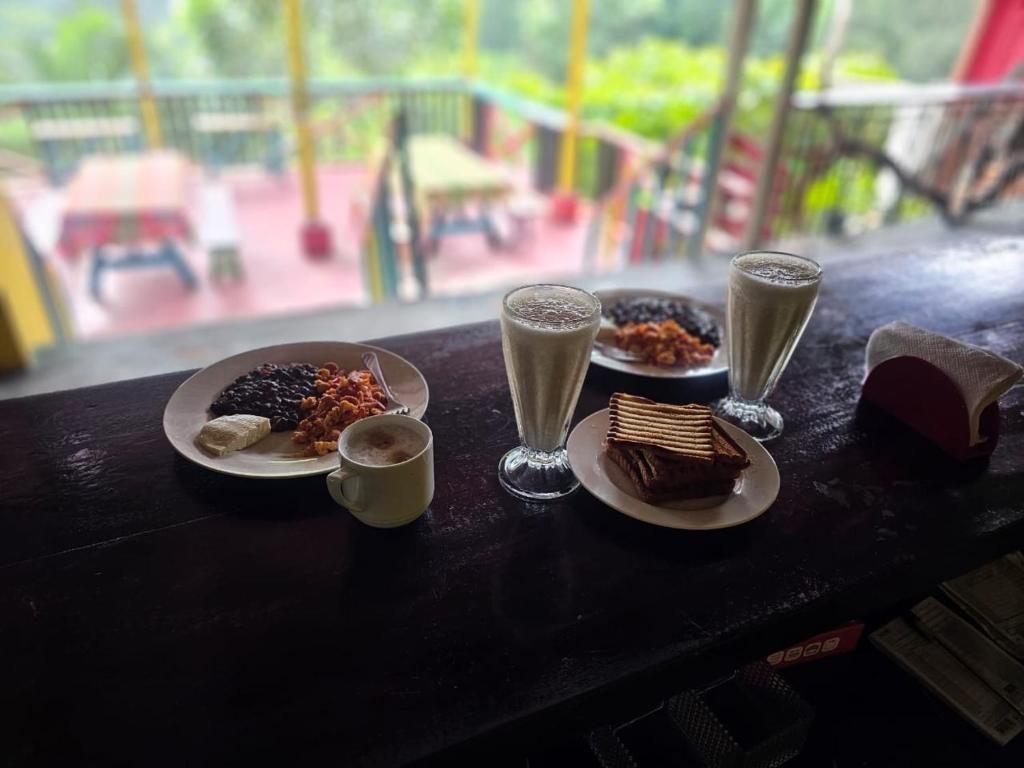 einen Tisch mit Teller mit Speisen und Gläsern Champagner in der Unterkunft CARIBbEAN Paradise Hotel in Lanquín