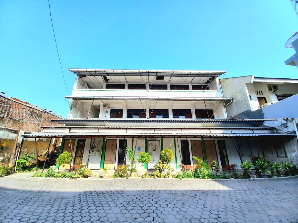 an old building with a cobblestone street in front of it at Hotel Jogja Kili Suci By Simply Homy in Yogyakarta