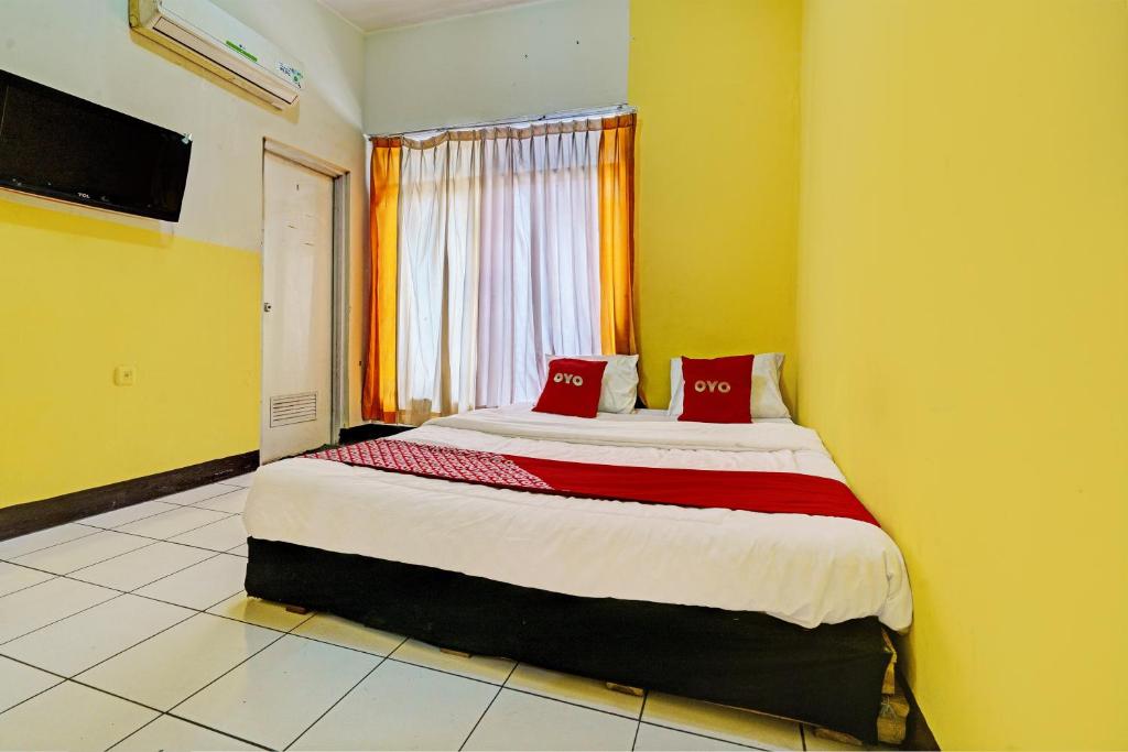 a bedroom with a large bed with red pillows at OYO 93229 P3 Guest House in Cilimus 2