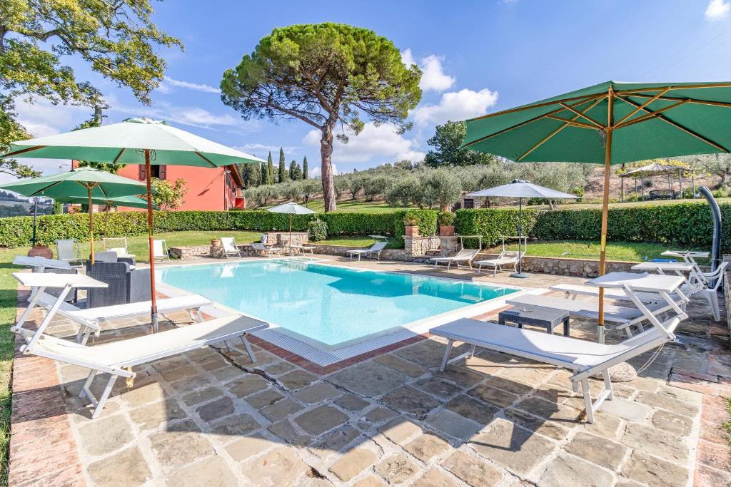 a swimming pool with chairs and umbrellas at Agriturismo Maramaldo - Happy Rentals in Castelfiorentino