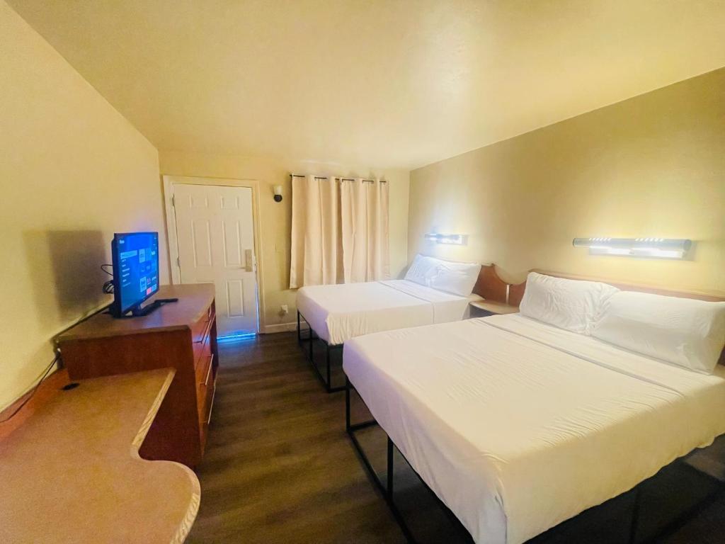 a hotel room with two beds and a television at Happy Smart Inn I-10 Eloy and Casa Grande in Eloy