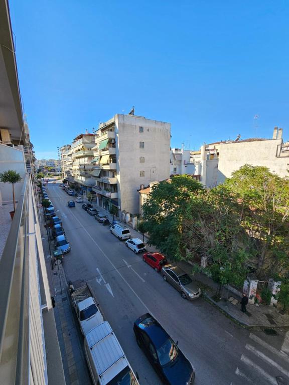 een uitzicht over de straat met geparkeerde auto's bij Elektras Apartment στο κέντρο της Λάρισας με δωρεάν πάρκιγκ in Larisa