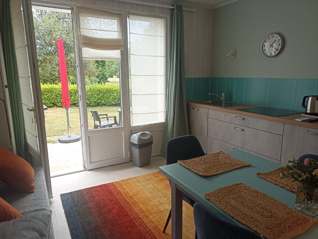 una cocina con mesa y una puerta a un patio en Gîtes de La Ferme De Kereven, en Bénodet