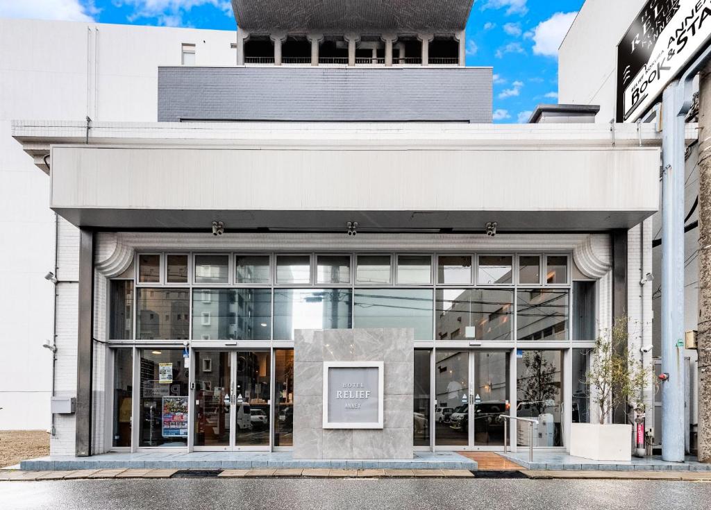 un edificio blanco con un cartel delante en Hotel Relief Kokura Annex en Kitakyushu