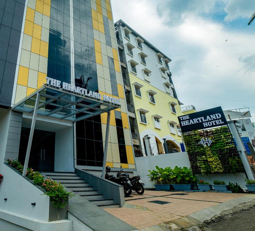un edificio con una motocicleta estacionada frente a él en The HEARTLAND Hotel en Thiruvananthapuram