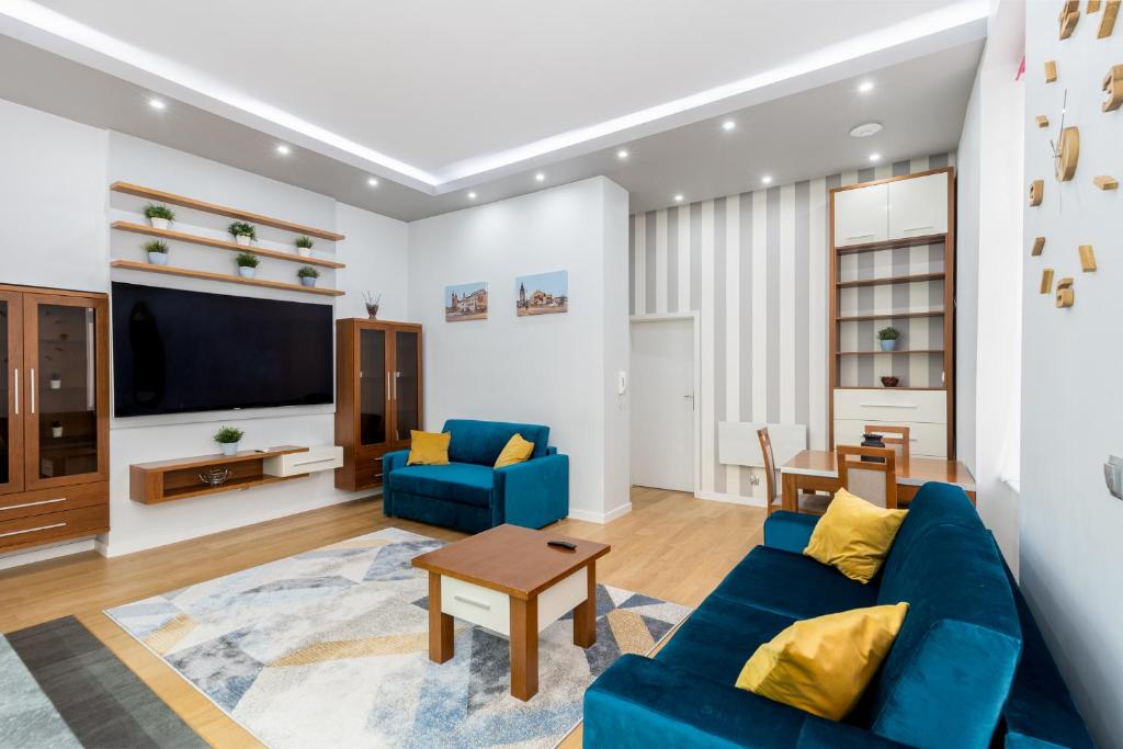 BlueApart with Terrace في كراكوف: غرفة معيشة مع أريكة زرقاء وتلفزيون