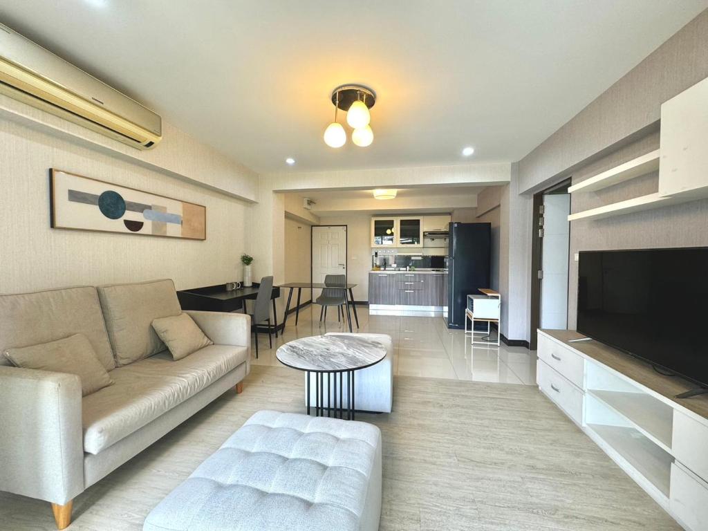 uma sala de estar com um sofá e uma mesa em Baan Sabai Rama IV Apartment em Bangkok