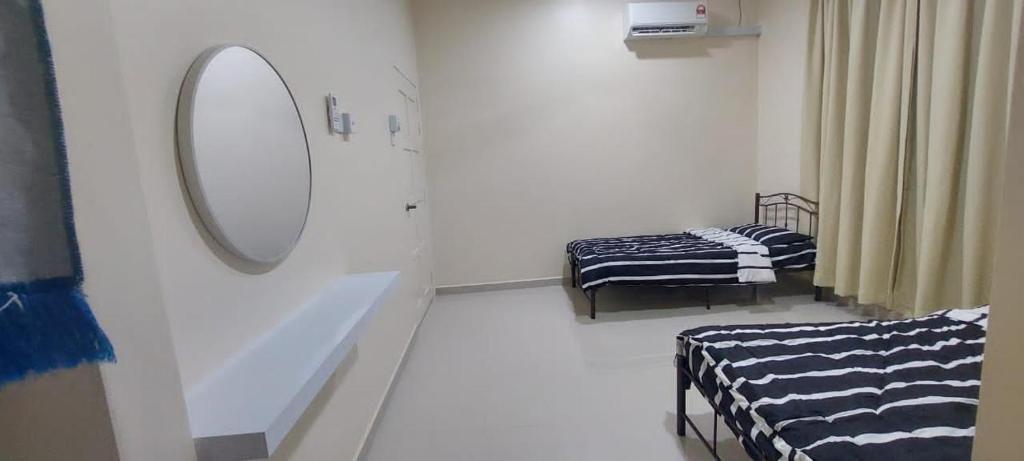 - une salle d'hôpital avec 2 lits et un miroir dans l'établissement Homestay Cassia Marang, à Marang