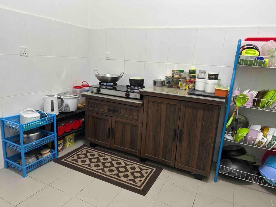 uma cozinha com armários de madeira e uma bancada com comida em Home at Kota Puteri em Batu Arang