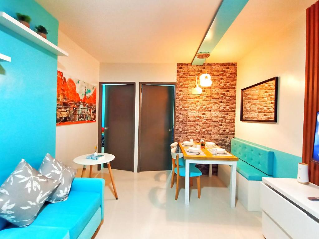 een woonkamer met een blauwe bank en een tafel bij Palawan Paradise Condotel 1L in Puerto Princesa City