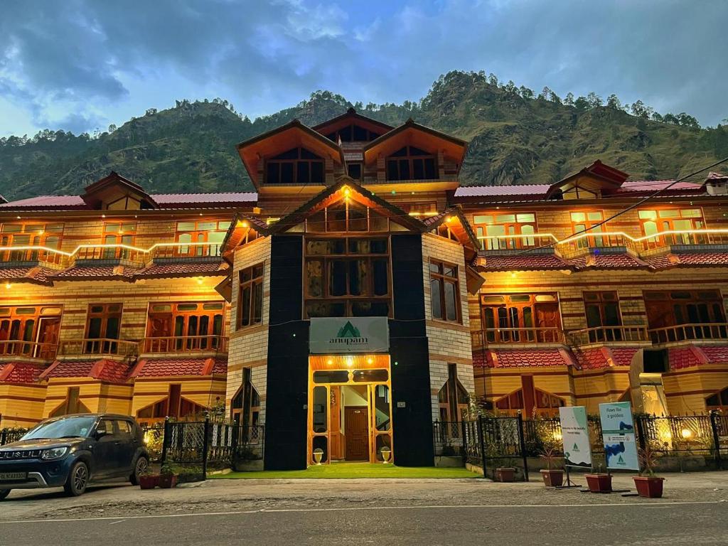 a building with a car parked in front of it at Hotel Anupam in Kasol