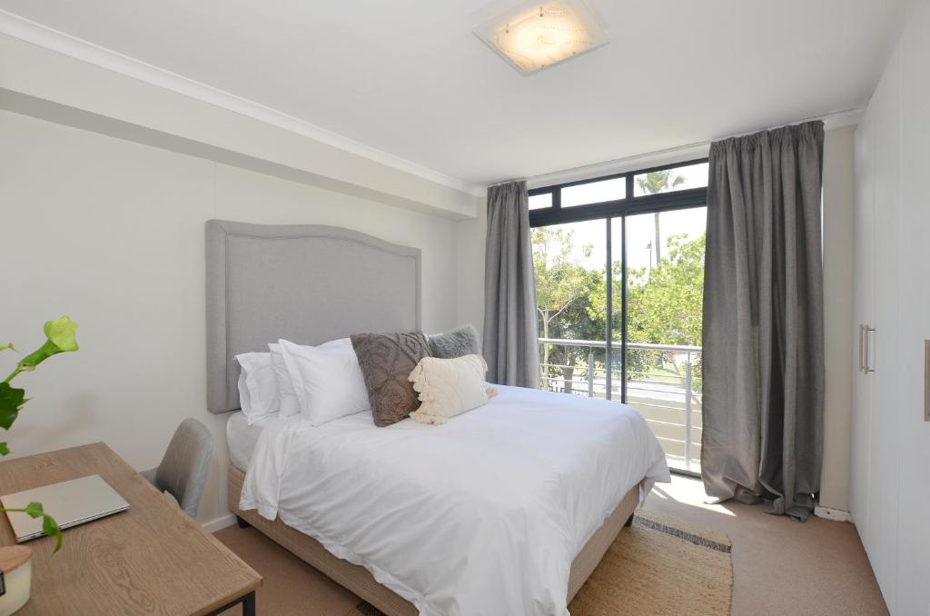 a bedroom with a bed and a large window at Apartment in Century City in Cape Town