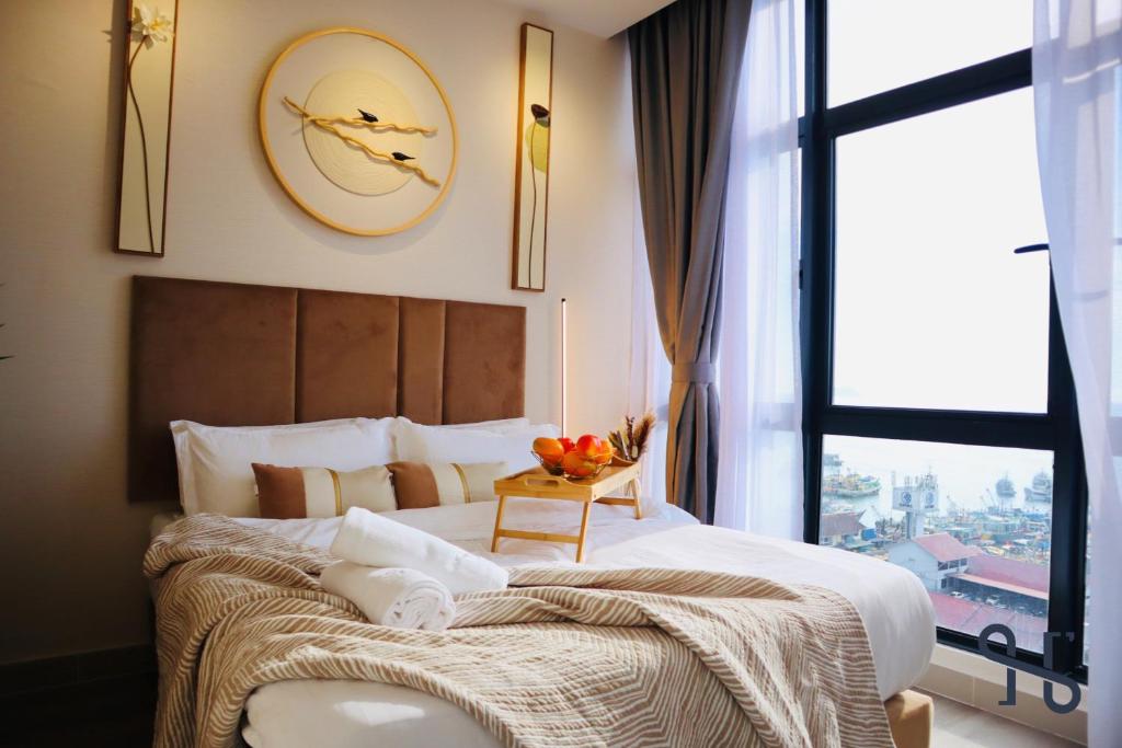 a bedroom with a large bed with a clock on the wall at The Shore by Homesuite' in Kota Kinabalu