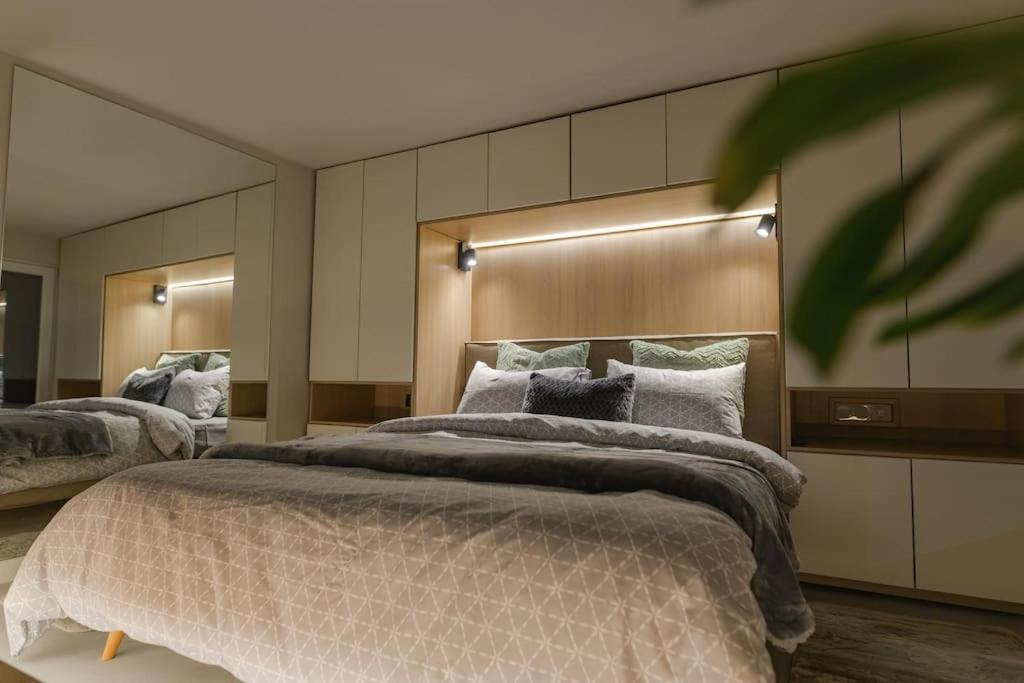 a large bedroom with two beds and two mirrors at Green and Grey loft 1 in Alexandroupoli