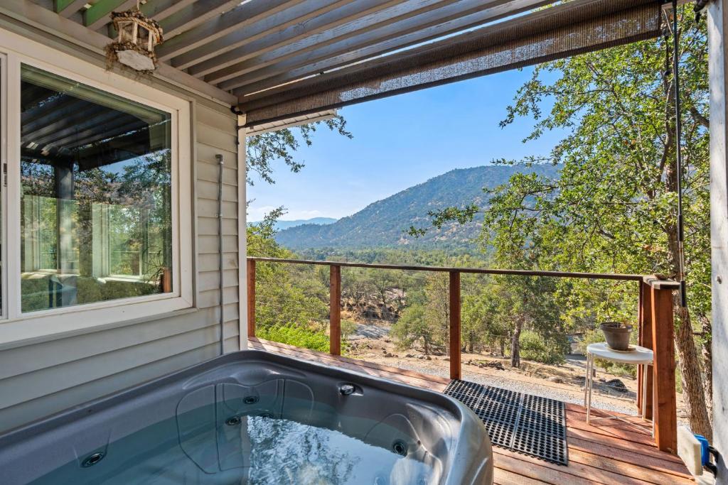 a hot tub on a deck with a view of the mountains at Views, Hot Tub, Outdoor Shower, 15m from Sequoia in Three Rivers