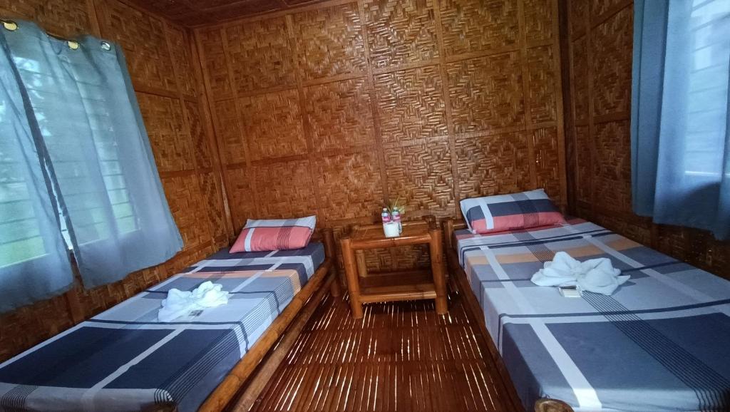 a room with two beds in a wooden cabin at LOONY CAFE in Loon