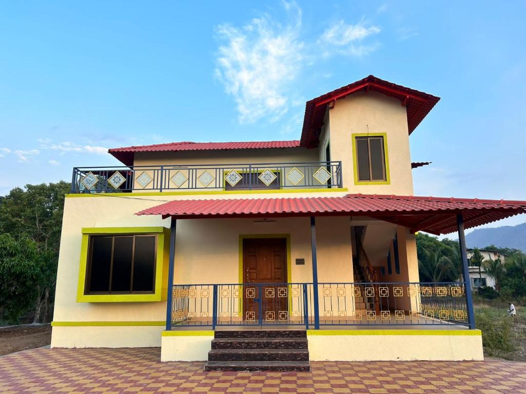 a small yellow house with a balcony at Asmi Palace, Bhaimala, Alibag in Vāgholi